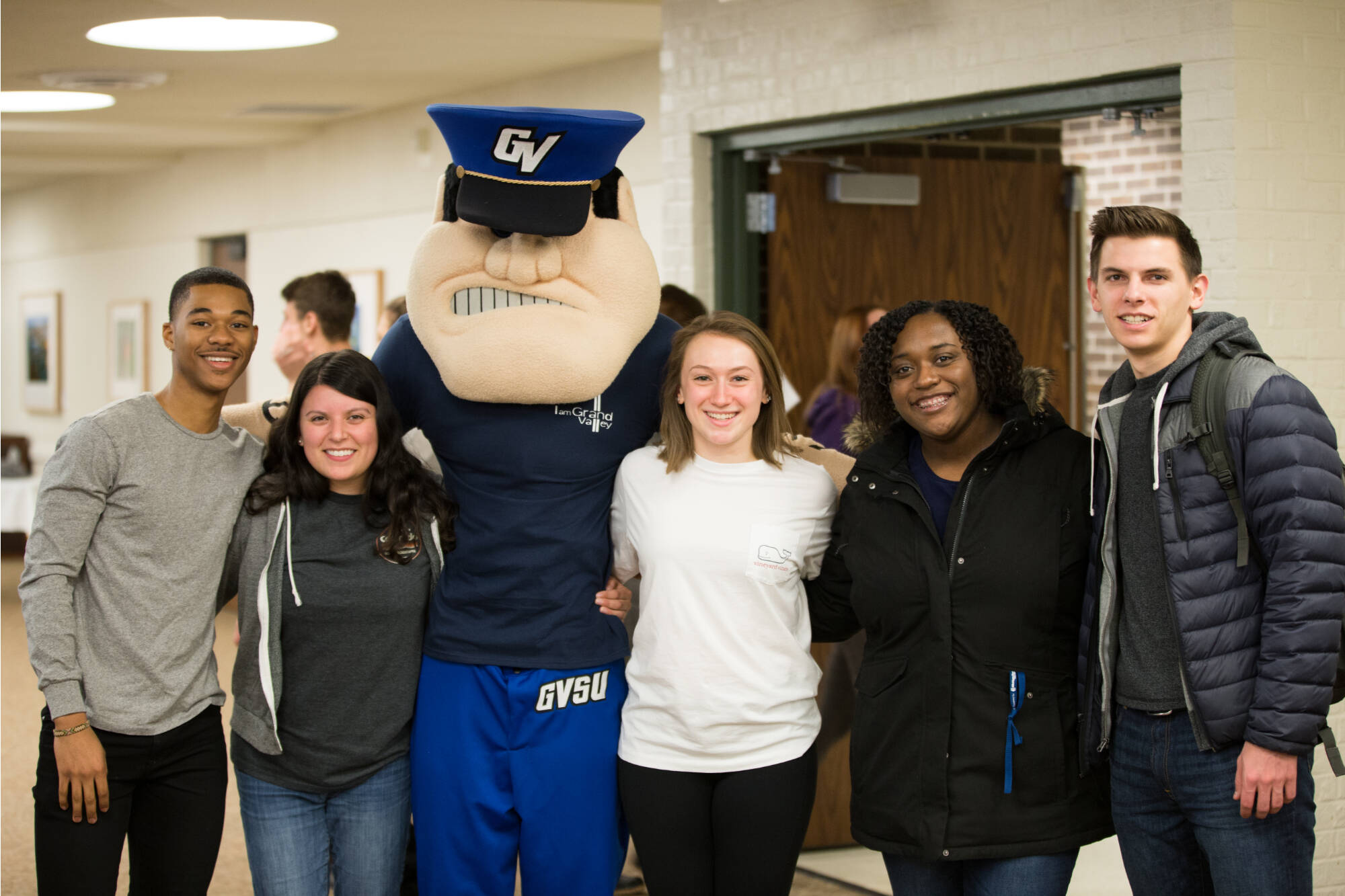 A group of students pose with GVSU Mascot, Louie the Laker.